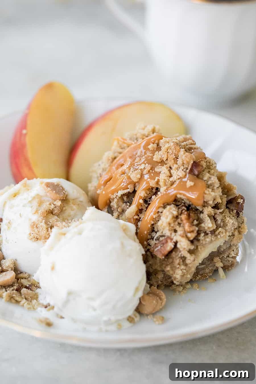 Ultimate Caramel Apple Crumble Bars 7 A beautiful display of caramel apple crumble bars, some served with ice cream and fresh apple slices.