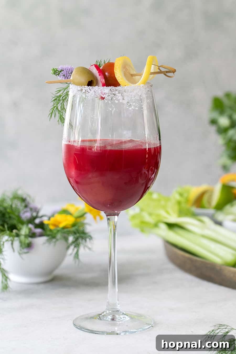 Craft Your Ultimate Home Bloody Mary Bar 15 A stunning beet juice Bloody Mary presented in an elegant wine glass, highlighting its unique purple hue.