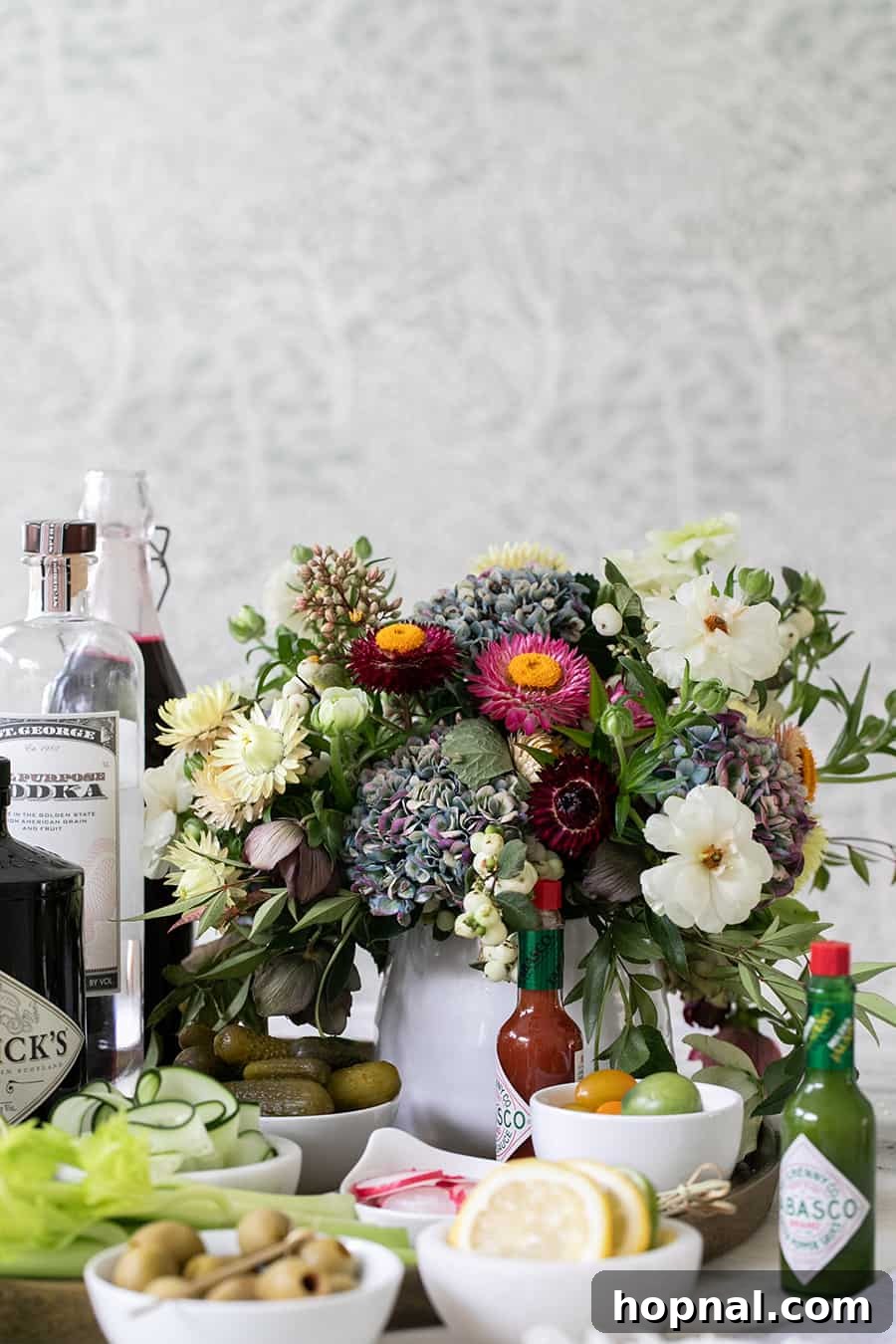 Craft Your Ultimate Home Bloody Mary Bar 4 A charming display of fresh flowers and various ingredients arranged for a homemade Bloody Mary bar.