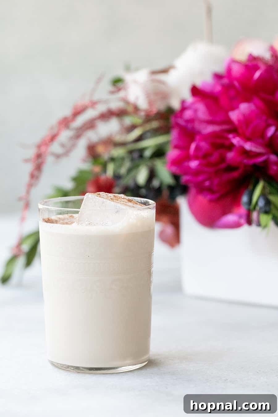Palermo Passion 2 Sicilian Kiss Cocktail with Baileys Irish Cream, Vodka, and Kahlua, served in elegant glasses on a table with pink flowers.