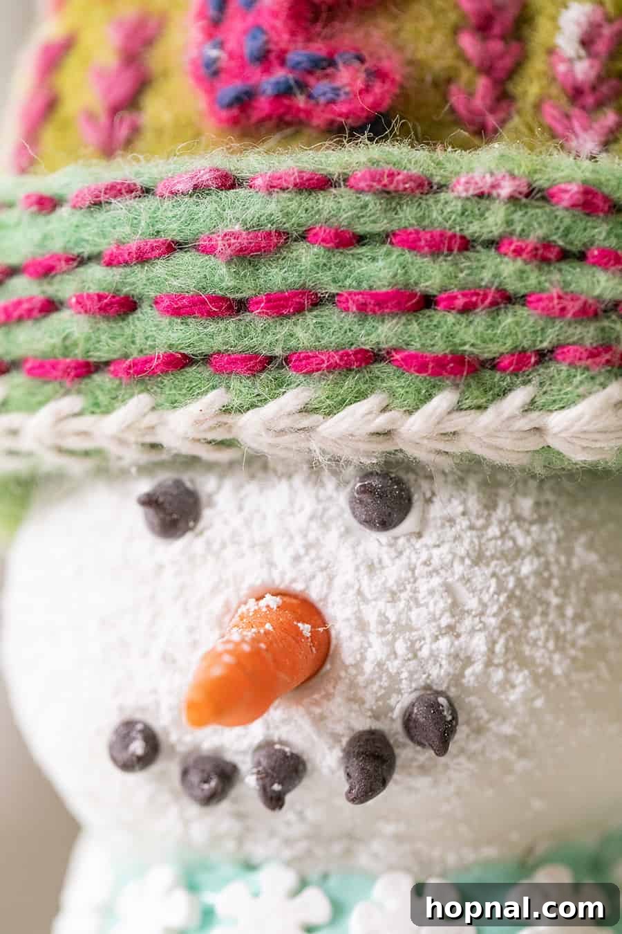 Decorating the gingerbread snowman cake with buttons and scarf