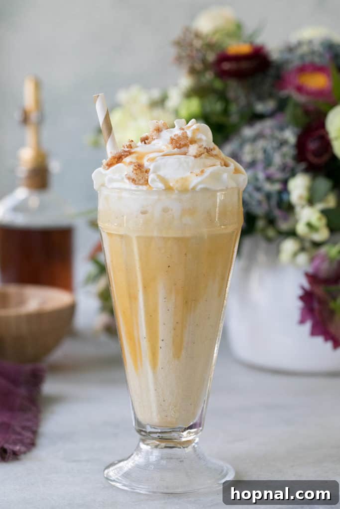 Rich caramel coffee milkshake topped with whipped cream and coffee cake crumbs, drizzled with caramel sauce.