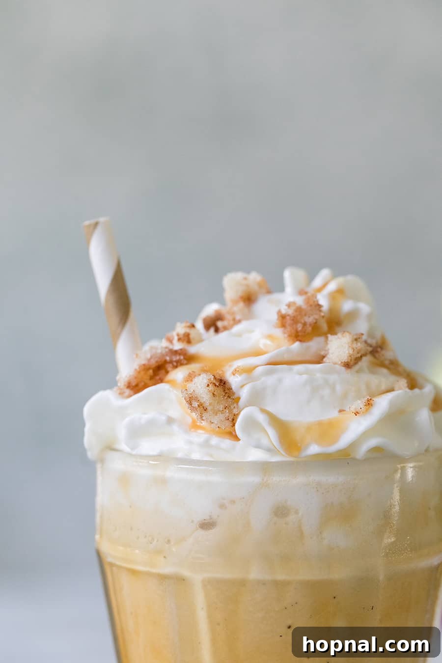 Close-up of a caramel coffee milkshake in a glass, with a caramel swirl visible.
