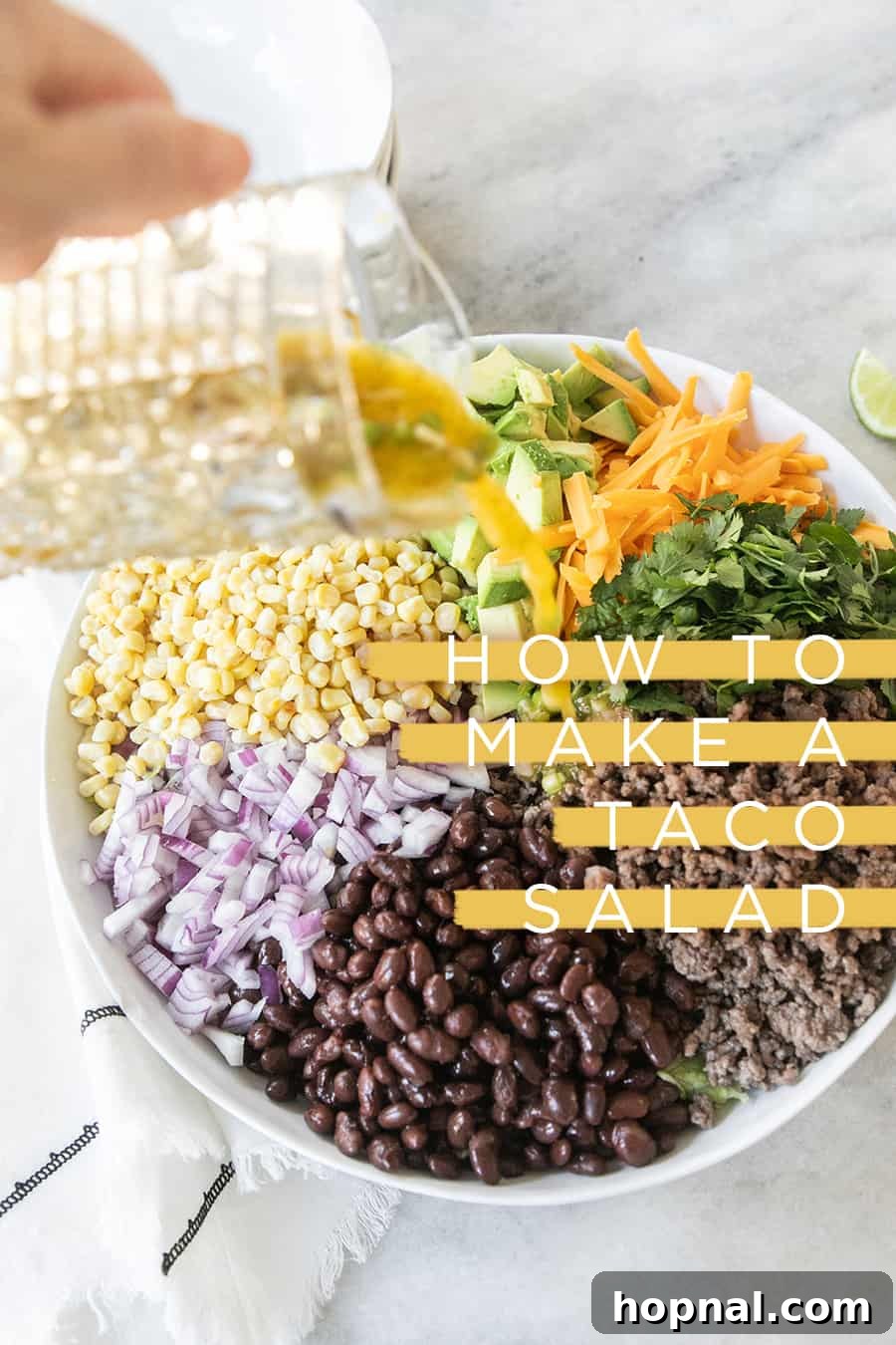 Southwest Fiesta Salad 2 Pouring zesty citrus dressing over a colorful ground beef taco salad, showcasing fresh ingredients.