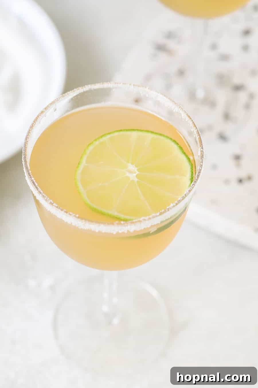 Classic Three-Ingredient Daiquiri 4 A perfectly prepared daiquiri on a marble table, garnished with a fresh lime slice.