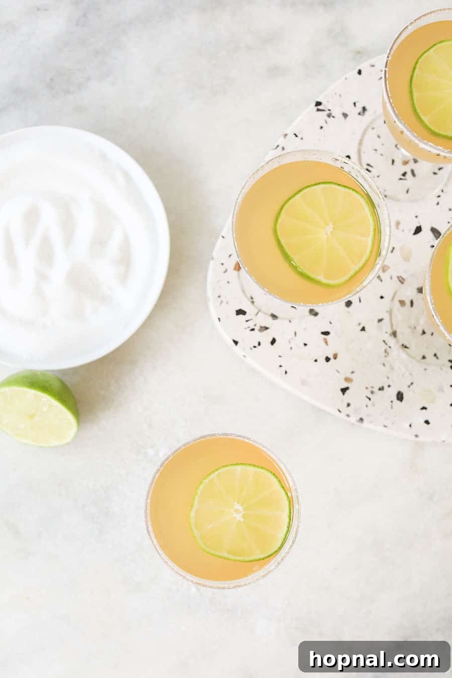 Classic Three-Ingredient Daiquiri 7 Overhead photo of two classic daiquiris in coupe glasses, perfectly garnished.