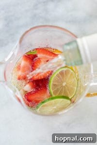 White wine sangria with vodka is poured into a glass pitcher for white sangria.