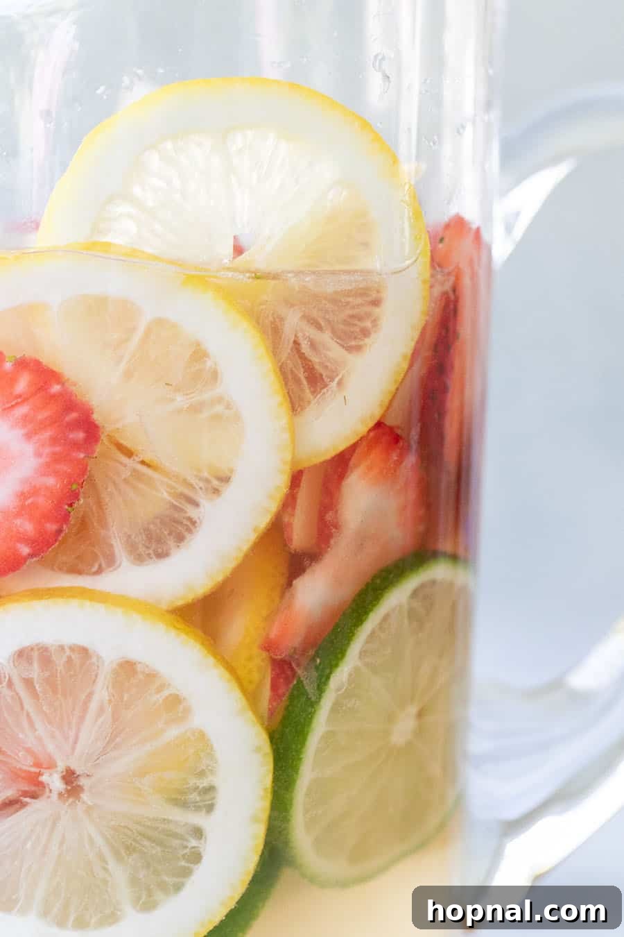 Easy white wine sangria recipe with lemon and lime slices and strawberries, and apple vodka. 