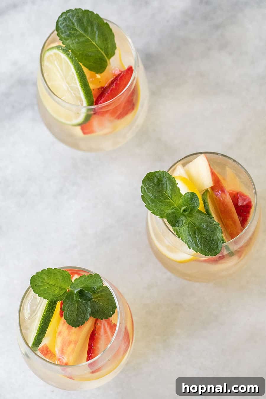 Three glasses of white wine sangria with fresh mint. 
