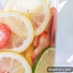 Easy white wine sangria recipe with lemon and lime slices and strawberries, and apple vodka.