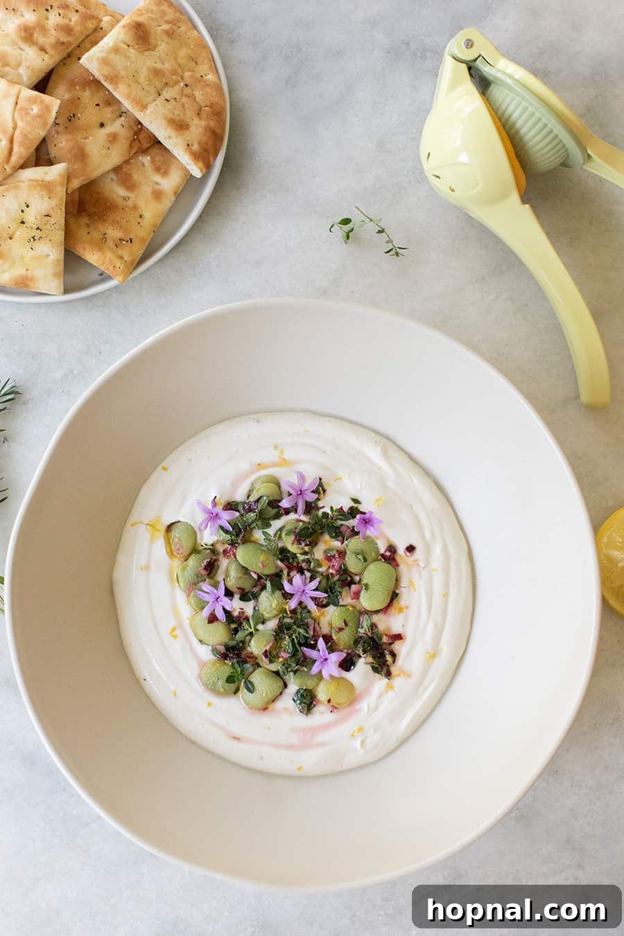 Close-up of the delicious tahini yogurt dip, richly adorned with a colorful lima bean topping, ready for dipping.