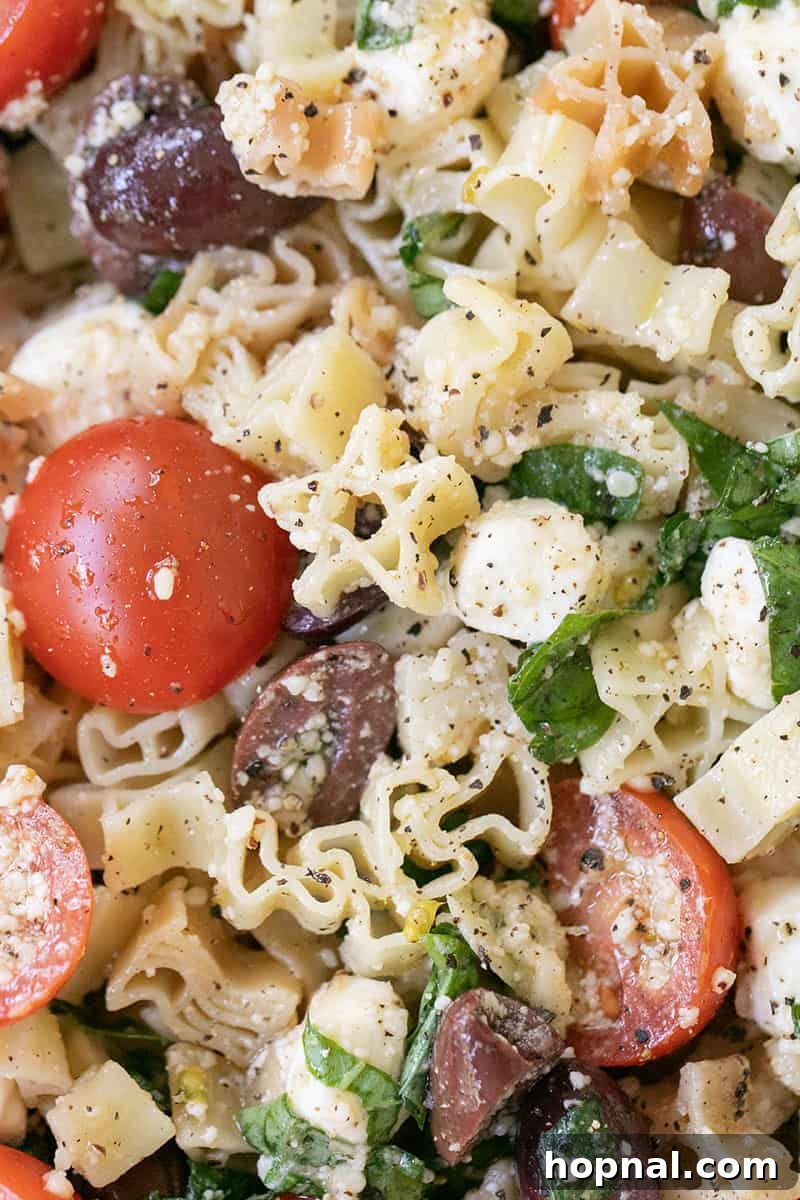 A serving of Summer Pasta Salad in a white bowl, ready to be enjoyed.