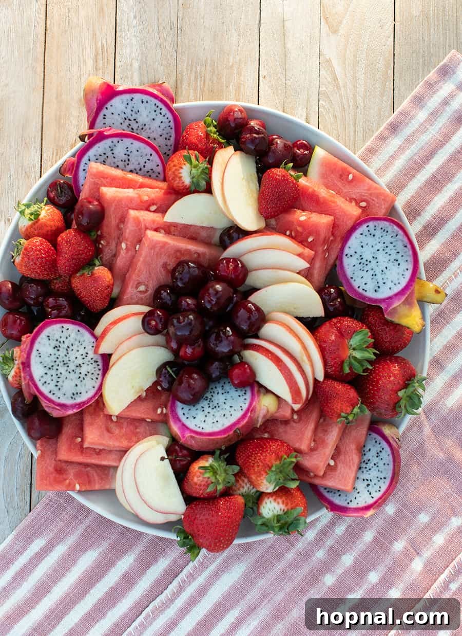 A vibrant fruit platter featuring only red and white fruits like watermelon, strawberries, and dragon fruit, beautifully arranged for a festive 4th of July celebration.