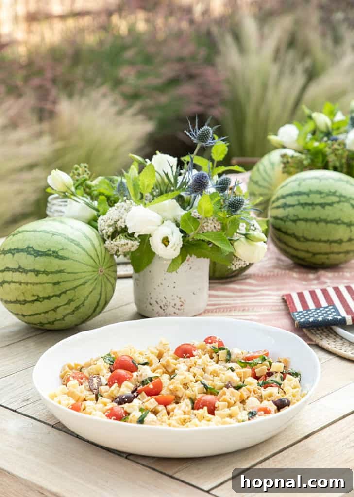 A festive table setting for a 4th of July party featuring delicious pasta salad and other patriotic treats, highlighting charming party ideas.