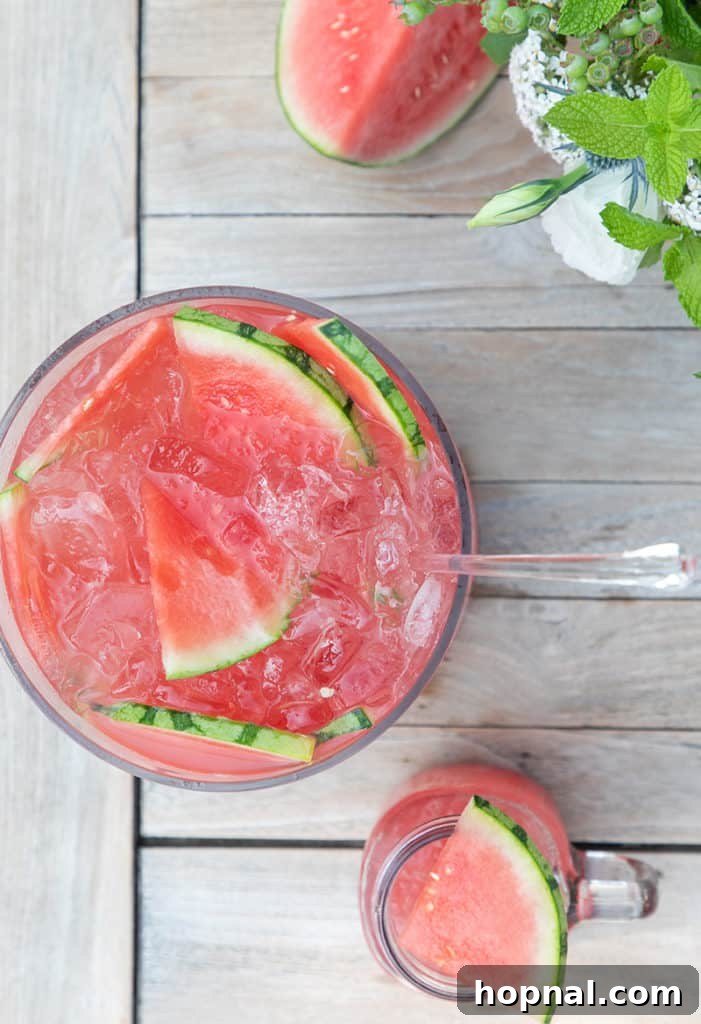 An overhead shot of a festive watermelon cocktail punch, beautifully garnished with fresh watermelon slices and mint, ready to be served.