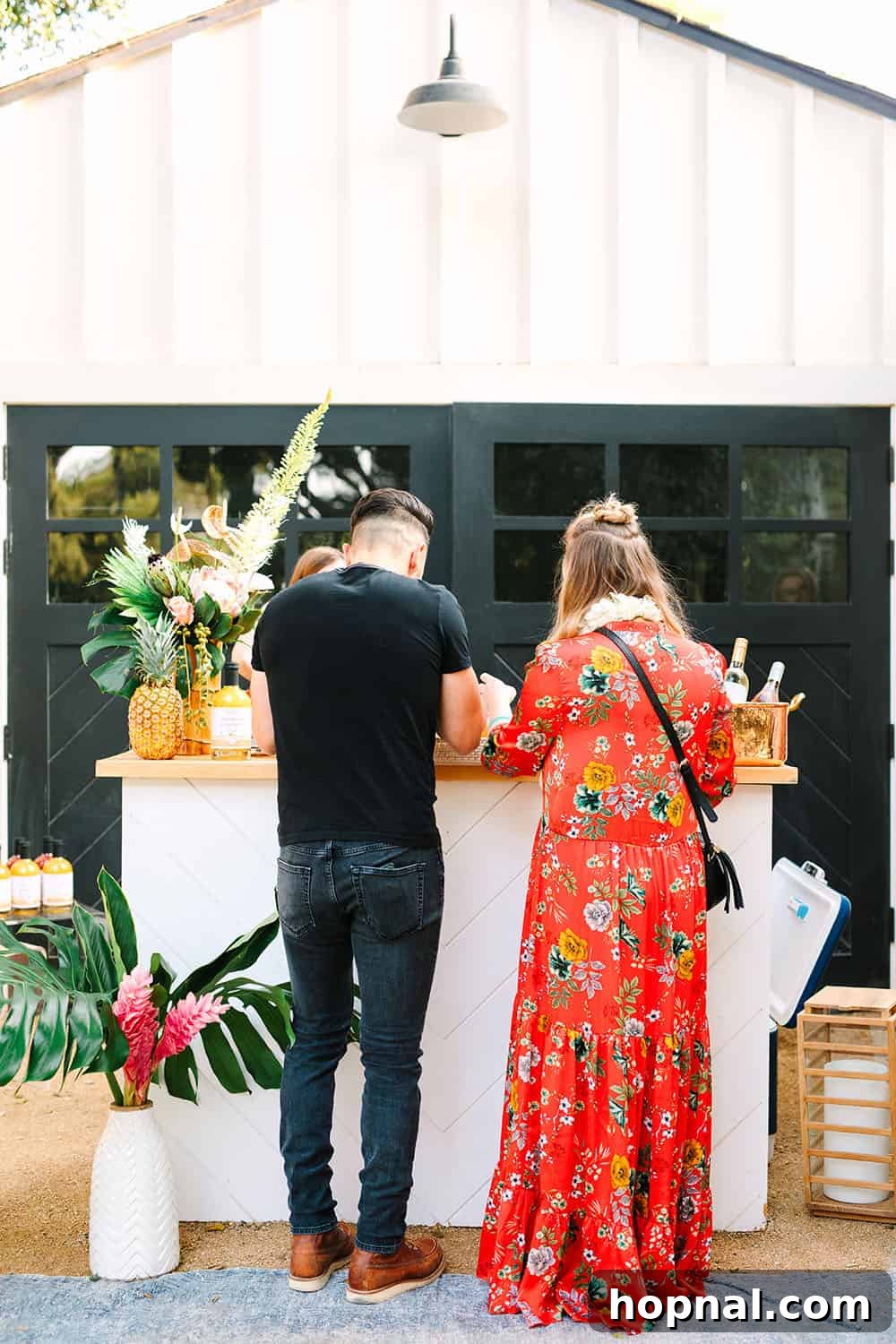 Guests enjoying the festive ambiance at a backyard summer tropical party, gathered around the outdoor bar.