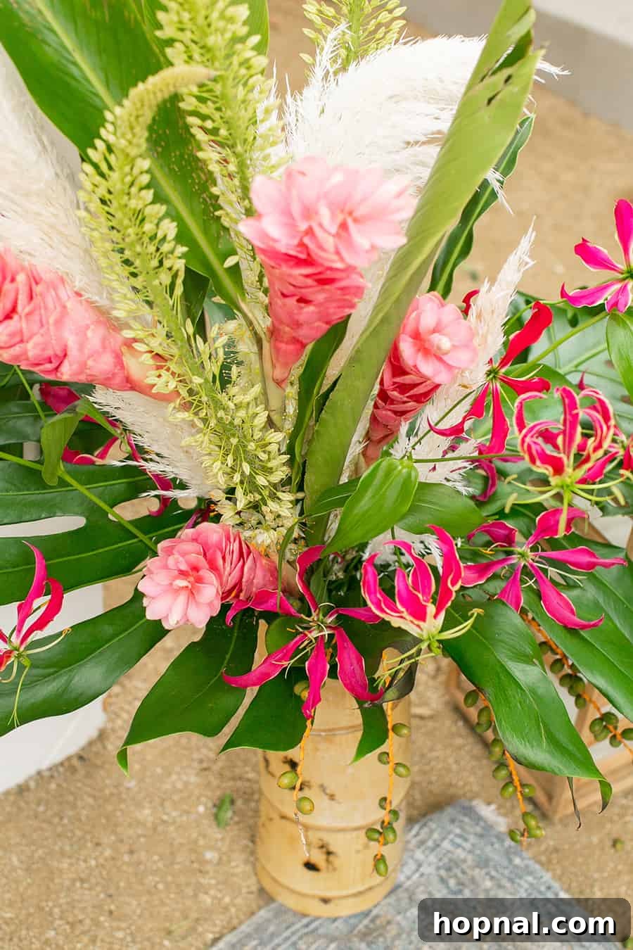 Lush tropical flowers displayed in elegant bamboo vases, enhancing the exotic decor of the party.