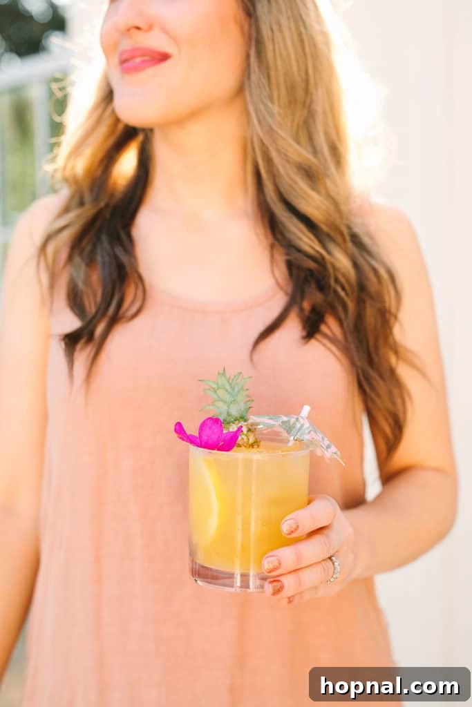 Hostess Eden Passante holding a refreshing tropical cocktail, showcasing vibrant party drinks.