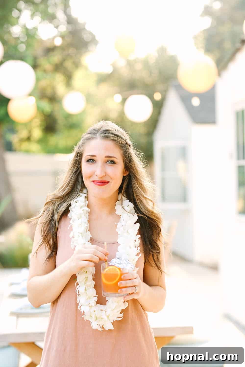 Eden Passante of Sugar and Charm, wearing a fresh lei, embodying the festive spirit of her tropical party.