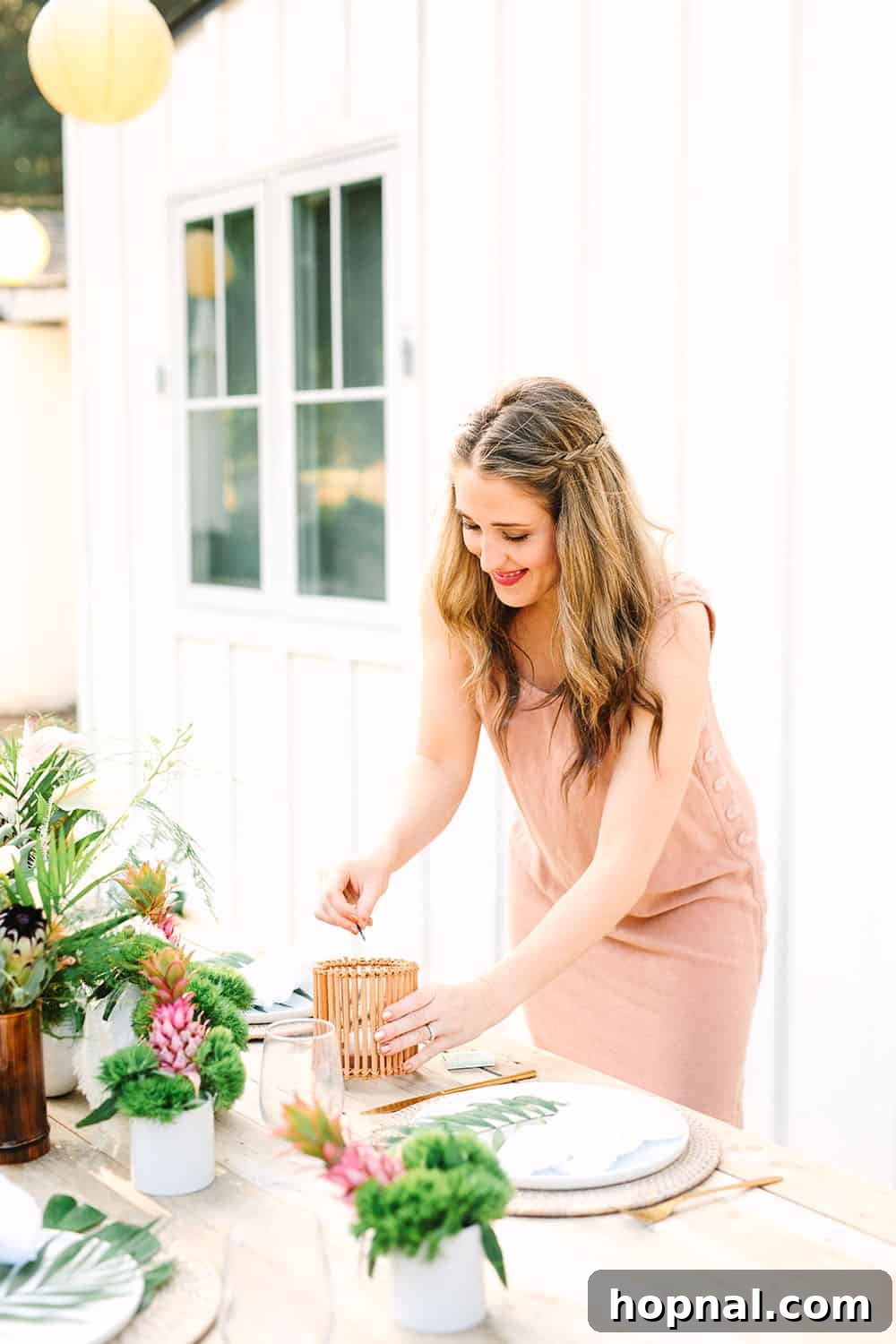 Eden Passante gracefully lighting a candle on the tropical table, adding to the evening's ambiance.