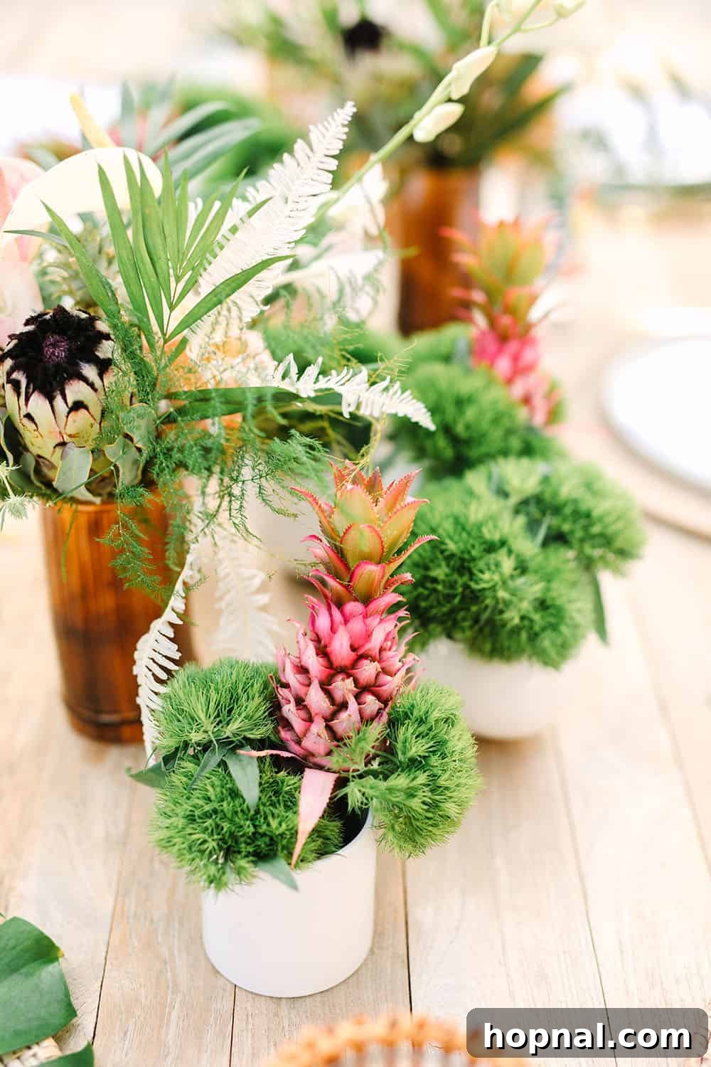 A stunning arrangement of tropical flowers accompanied by a decorative pink pineapple, perfect for a backyard party centerpiece.