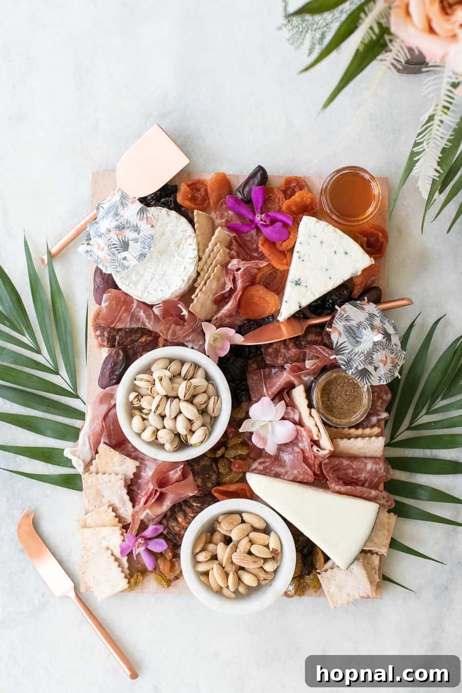 A gourmet charcuterie board featuring a tropical theme, abundant with exotic fruits, cheeses, and cured meats.