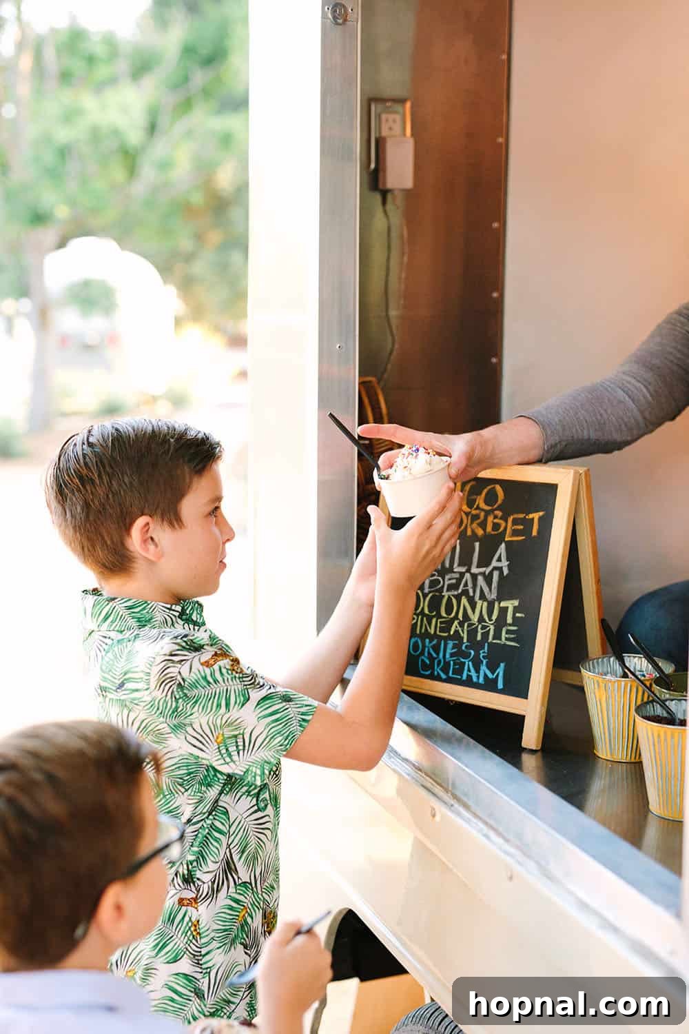 Serving children ice cream from a delightful ice cream truck at a tropical summer party, a highlight for younger guests.