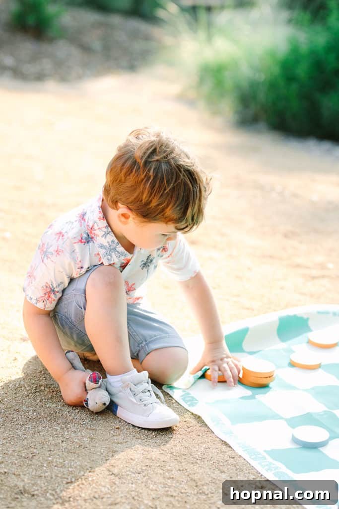 A young boy engrossed in a game of checkers, a fun activity for kids at the party.