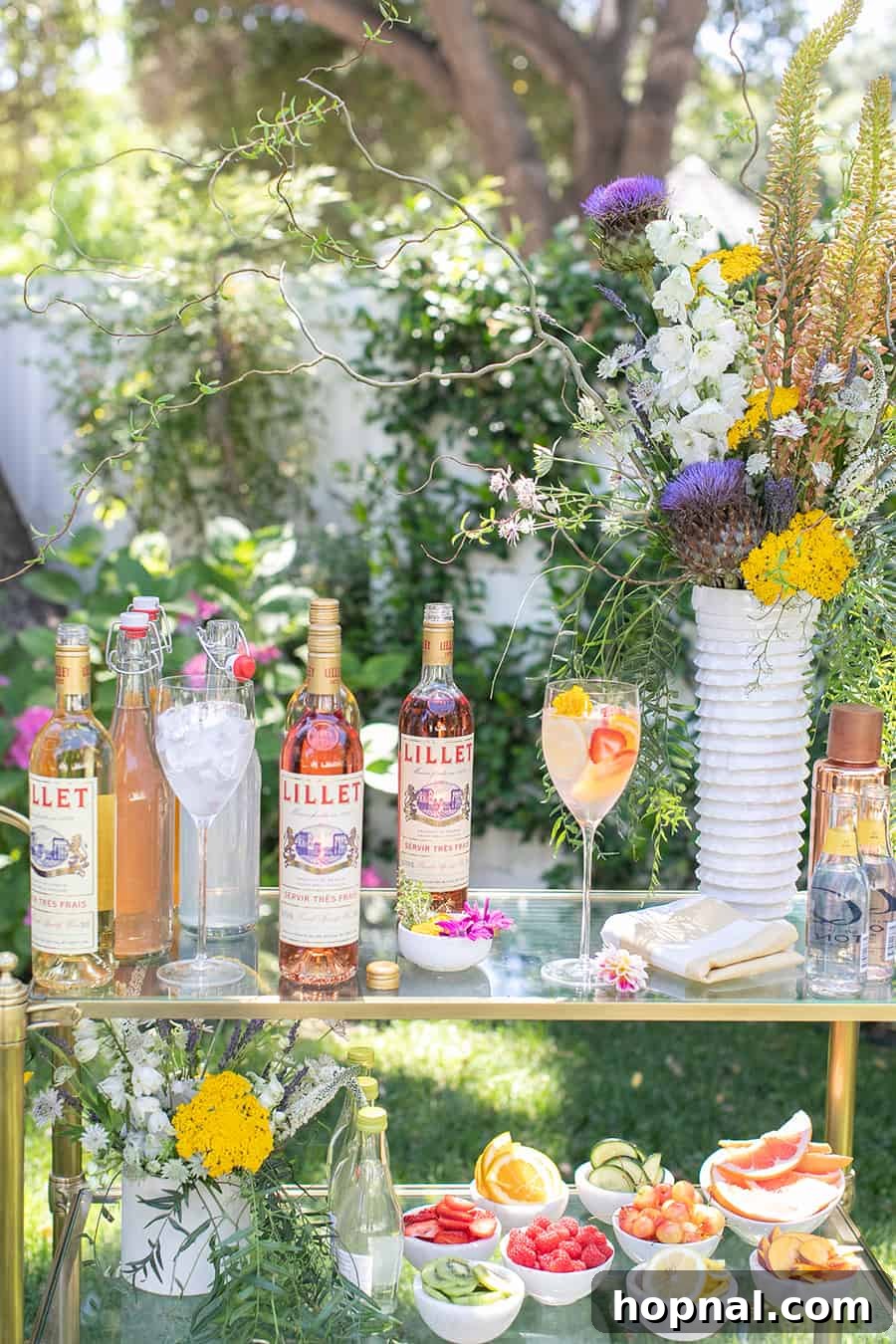 Craft Your Own Spritzer Bar 2 Bottles of Lillet on gold bar cart with flowers, inviting guests to create their own spritzer.