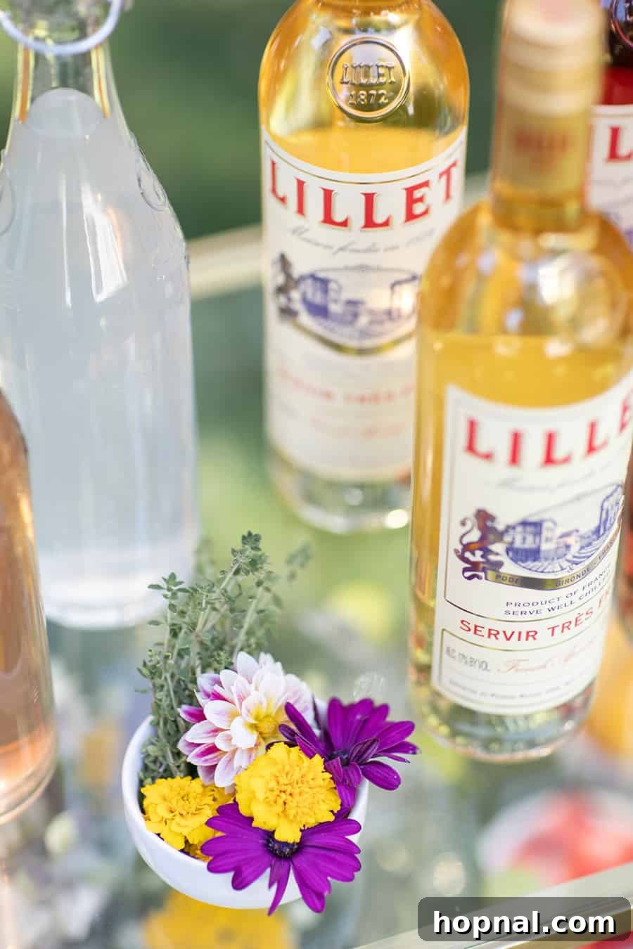 Craft Your Own Spritzer Bar 13 A bottle of Lillet on a stylish bar cart, adorned with fresh flowers, ready to serve refreshing spritzers.