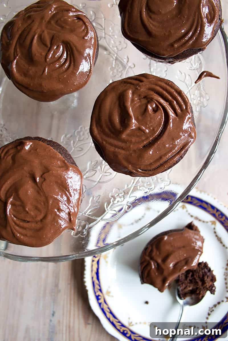 Gooey chocolate cupcakes artfully arranged on a cake stand, with frosting melting slightly over the edges.