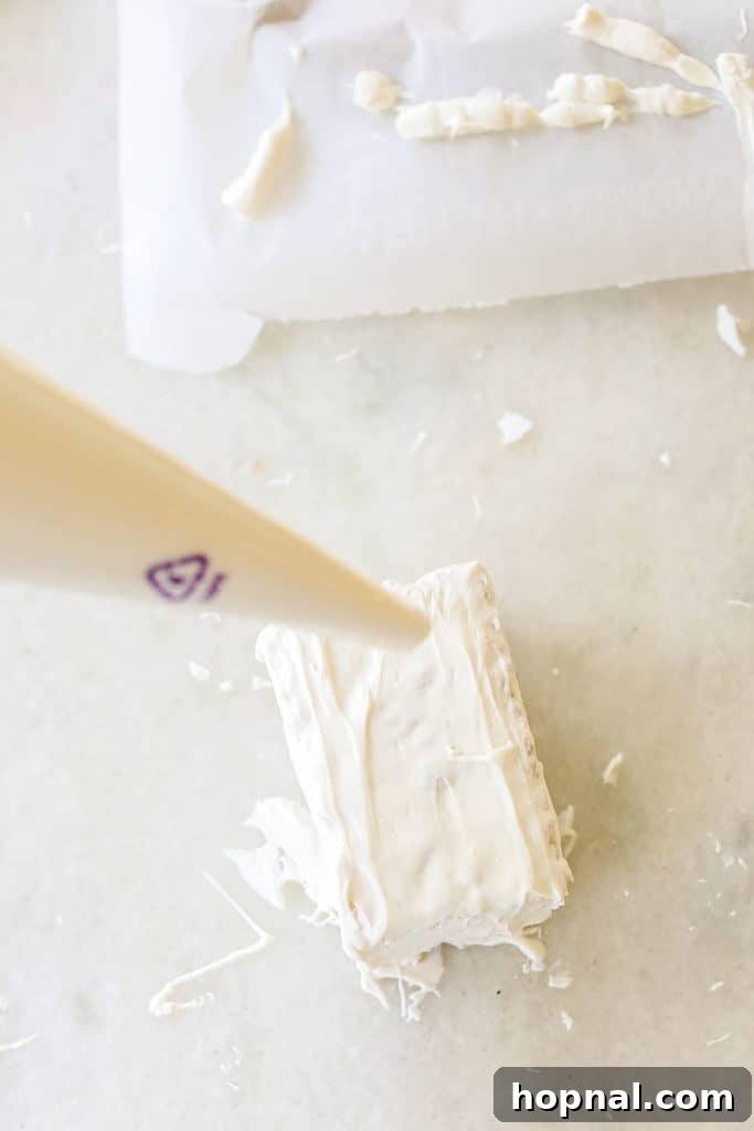 Drizzling melted white chocolate over Rice Krispie treats in a crisscross pattern to create mummy bandages.