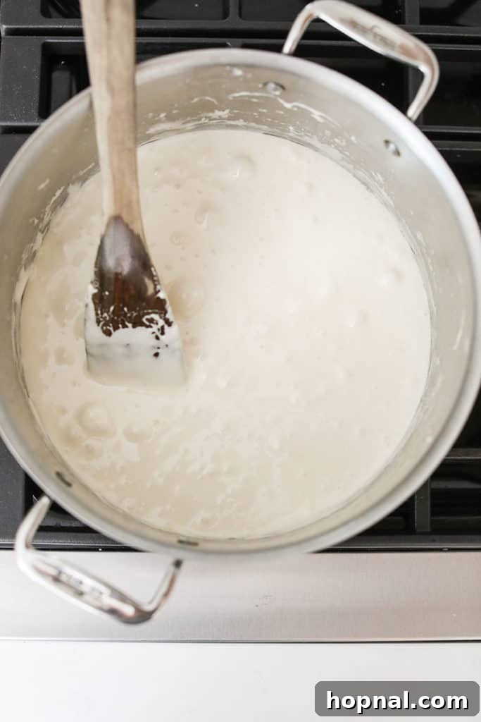 Stirring marshmallows into the fragrant browned butter until they are completely smooth and melted.