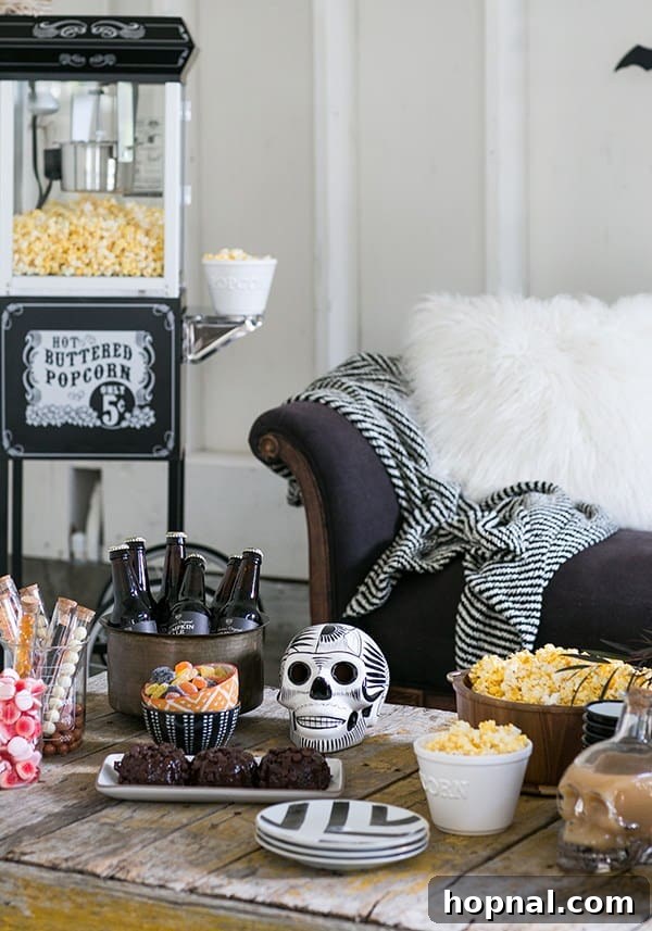 A cozy Halloween movie night setup with pumpkins, popcorn, and blankets, perfect for a spooky film marathon.