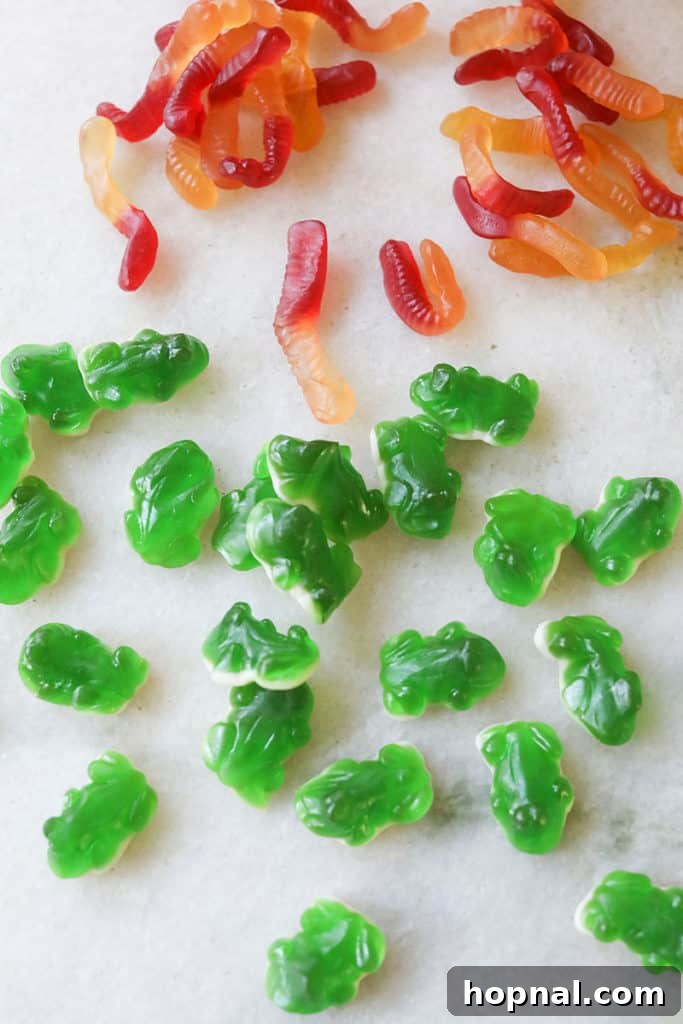 Gummy candy garnishes like worms and frogs for a Halloween punch.