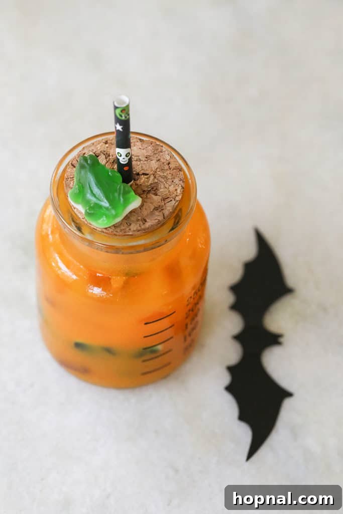 Bright orange Halloween punch for kids served in a glass.
