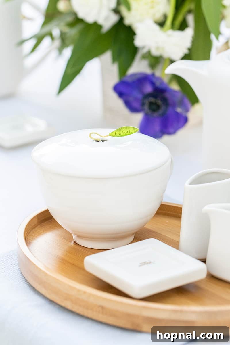 A pristine white tea cup and saucer resting on a natural bamboo plate, ready for an exquisite tea service.