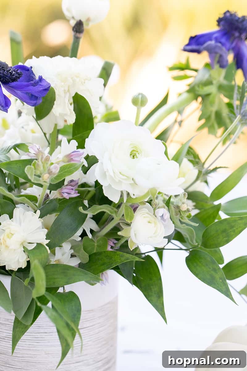 A lavish tea party bridal shower table arrangement, adorned with an abundance of fresh flowers and rustic decor elements.