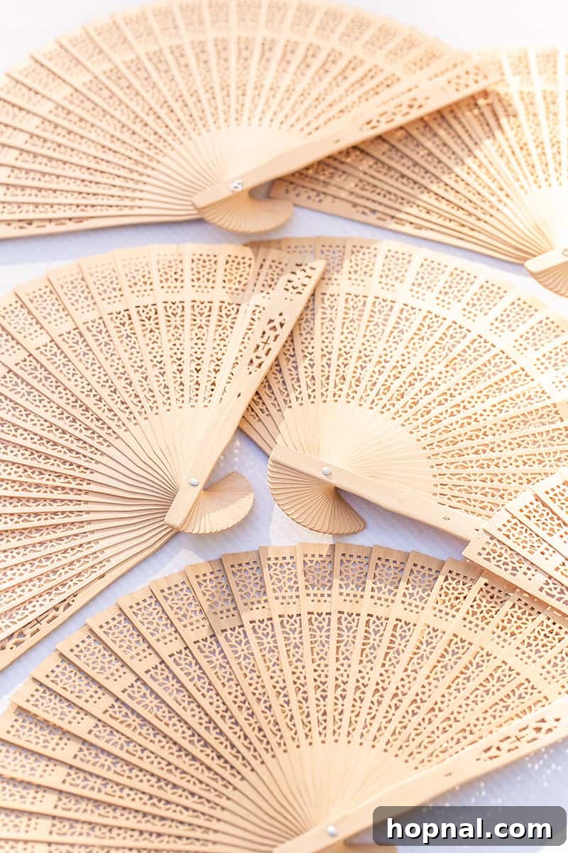 Elegant wooden fans arranged as guest favors, offering comfort and style for an outdoor tea party.