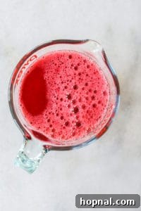 Cranberry jello in a container ready for pouring with a spout.