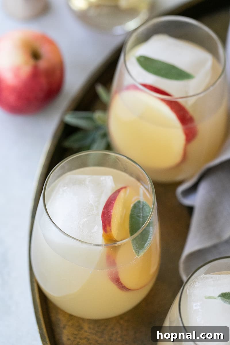 Sparkling Apple Ginger Wine Spritzer Your Fall Drink 2 Apple and Ginger Spritzer on a gold tray, perfect for serving as a Thanksgiving cocktail.