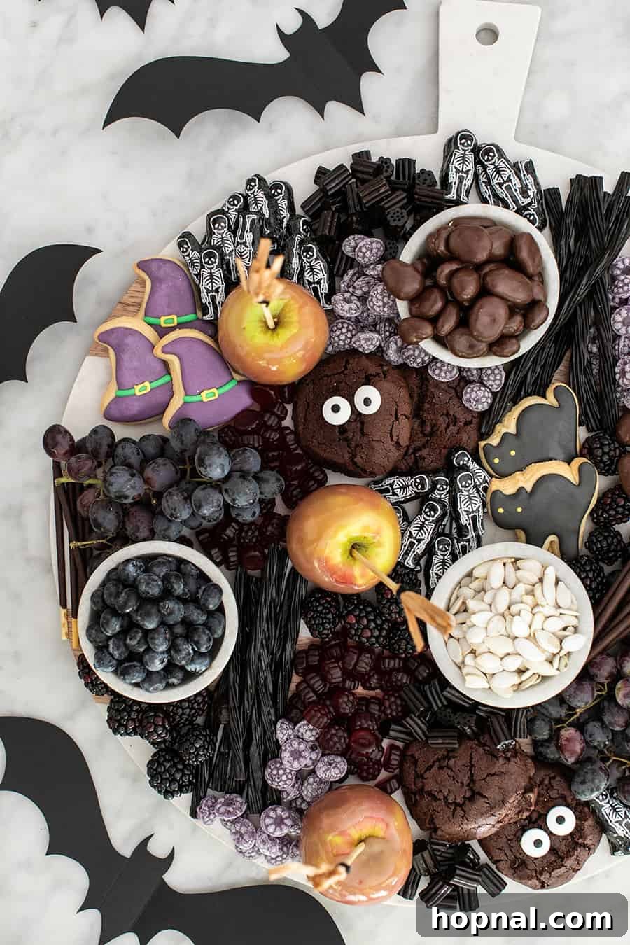 Assortment of Halloween desserts on a platter for kids, including cookies, candies, and small themed treats.