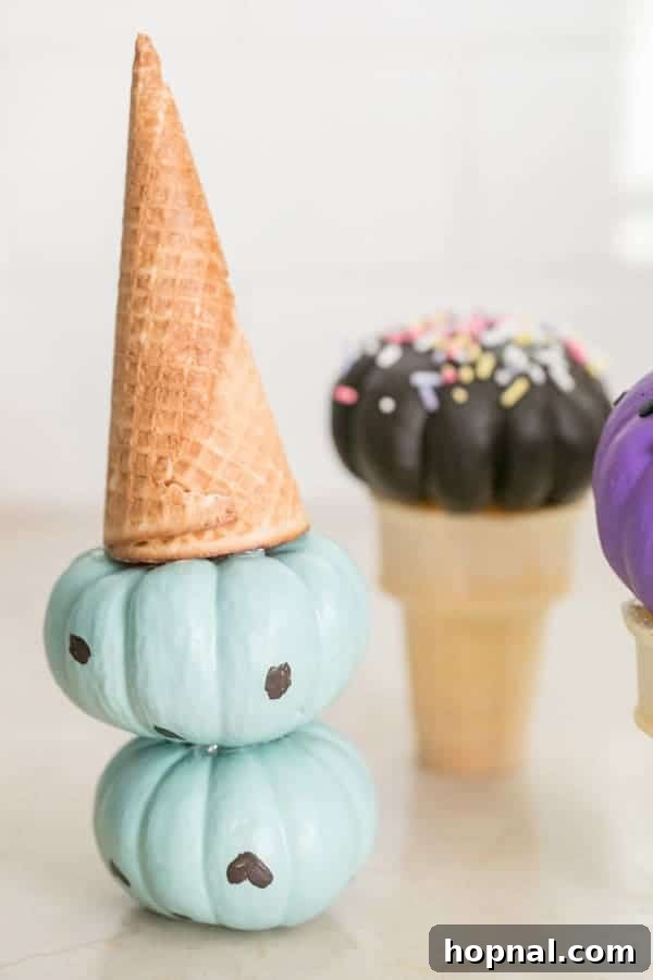Painted pumpkin ice cream cones, a creative and safe Halloween craft for toddlers and young children, using mini pumpkins.