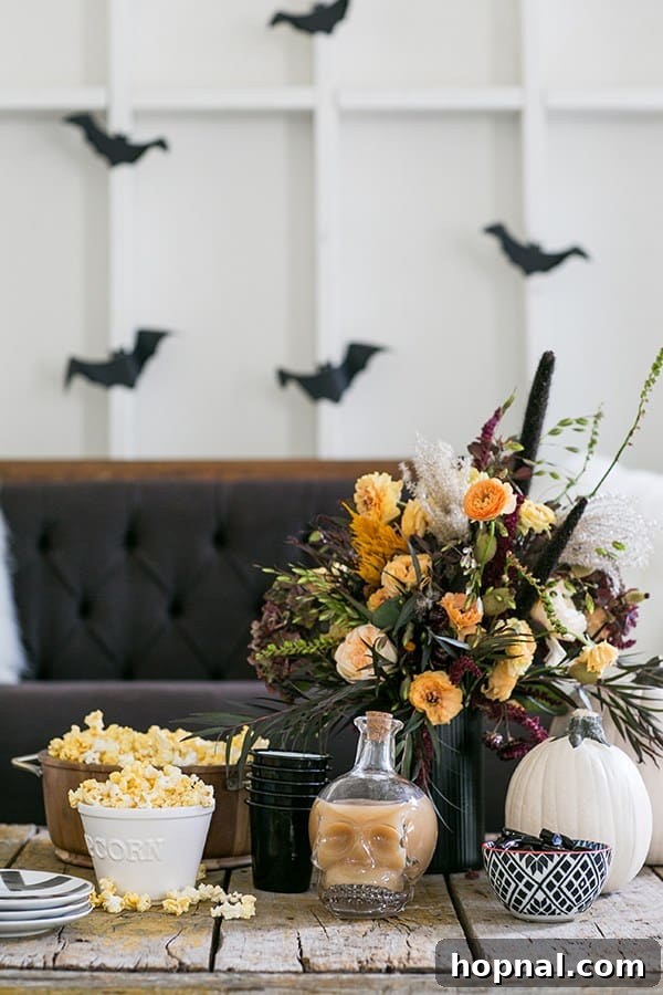 Cozy Halloween movie night setup for kids with blankets, pillows, and festive treats, featuring a family-friendly movie on screen.