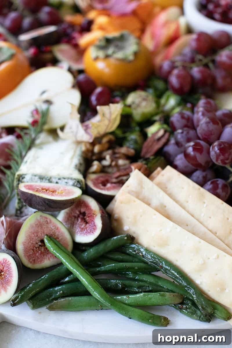 Green beans, crackers and figs on a board. 