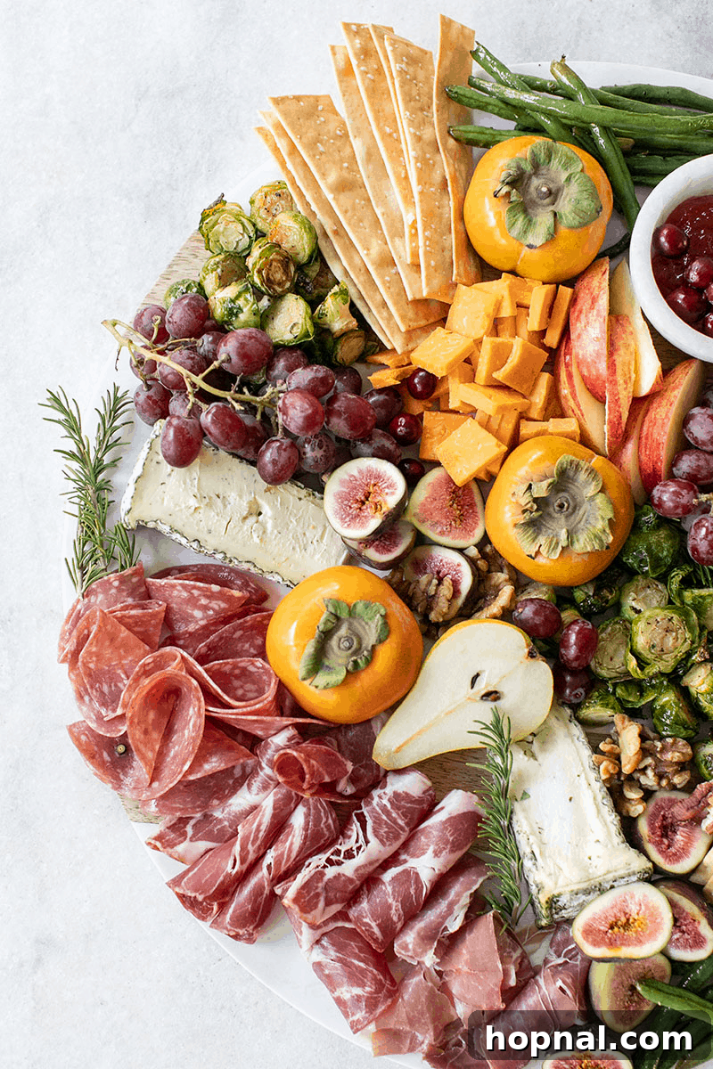 A lavish Thanksgiving appetizer platter, artfully arranged with various cheeses, cured meats, crackers, fruits, and nuts for a sophisticated starter.