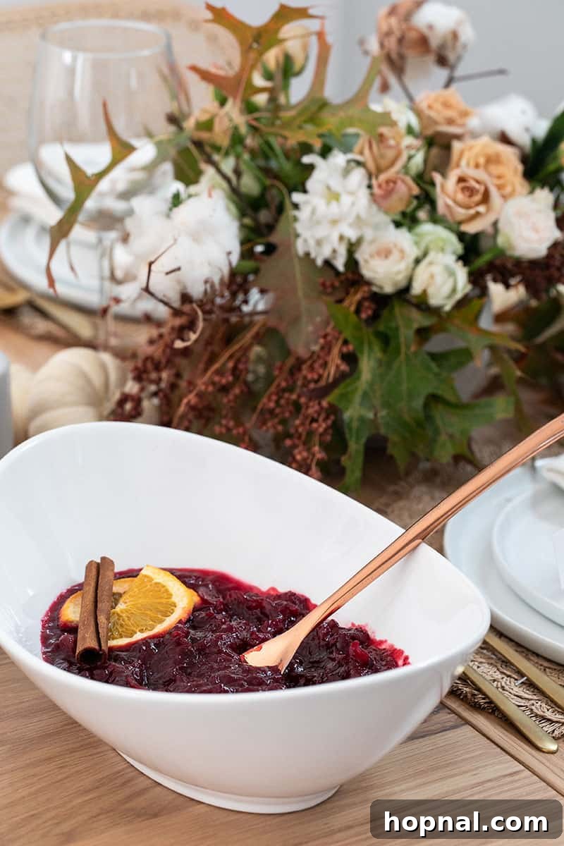 Homemade cranberry sauce, glistening in a bowl with a brass spoon, showcasing its rich color and texture.