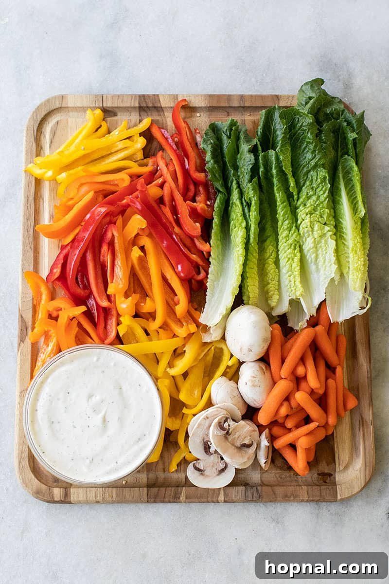 Assortment of fresh vegetables, including bell peppers, carrots, and lettuce, neatly arranged on a cutting board, ready to be prepared for a Thanksgiving turkey platter for kids.