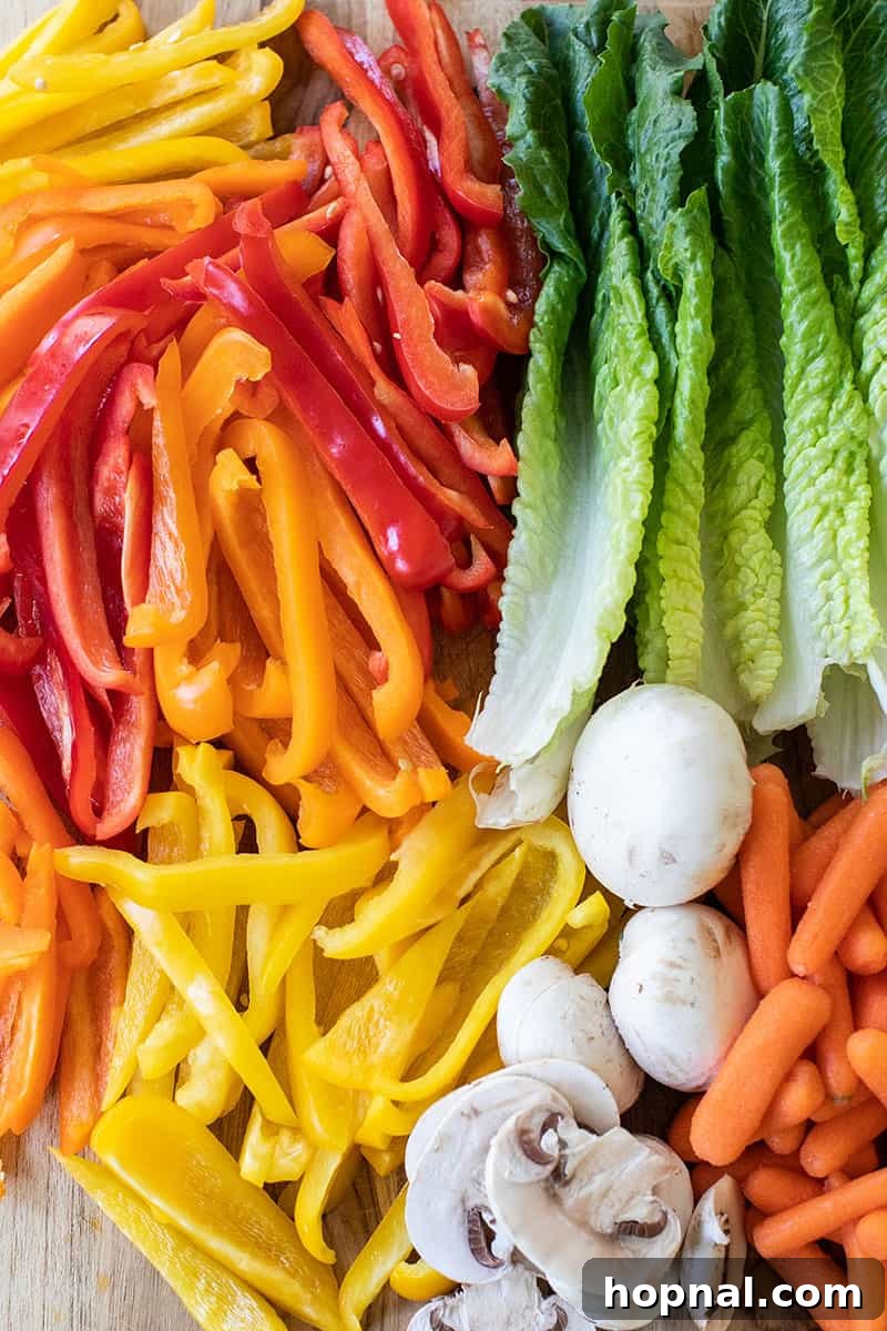 Close-up view of fresh, vibrant vegetables, including sliced bell peppers, baby carrots, and lettuce, perfectly prepped on a cutting board for a Thanksgiving appetizer.