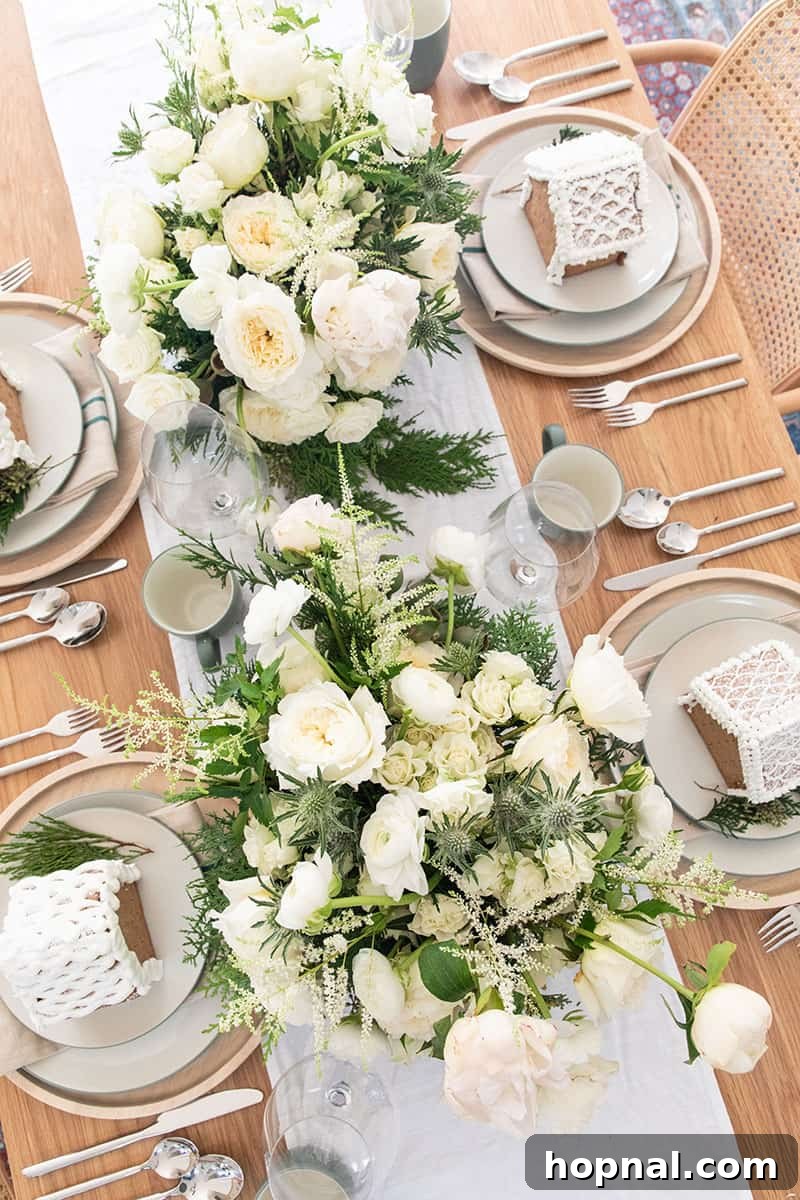 Overhead photo of a beautifully arranged Christmas Eve table with flowers, gingerbread houses, and festive decor.